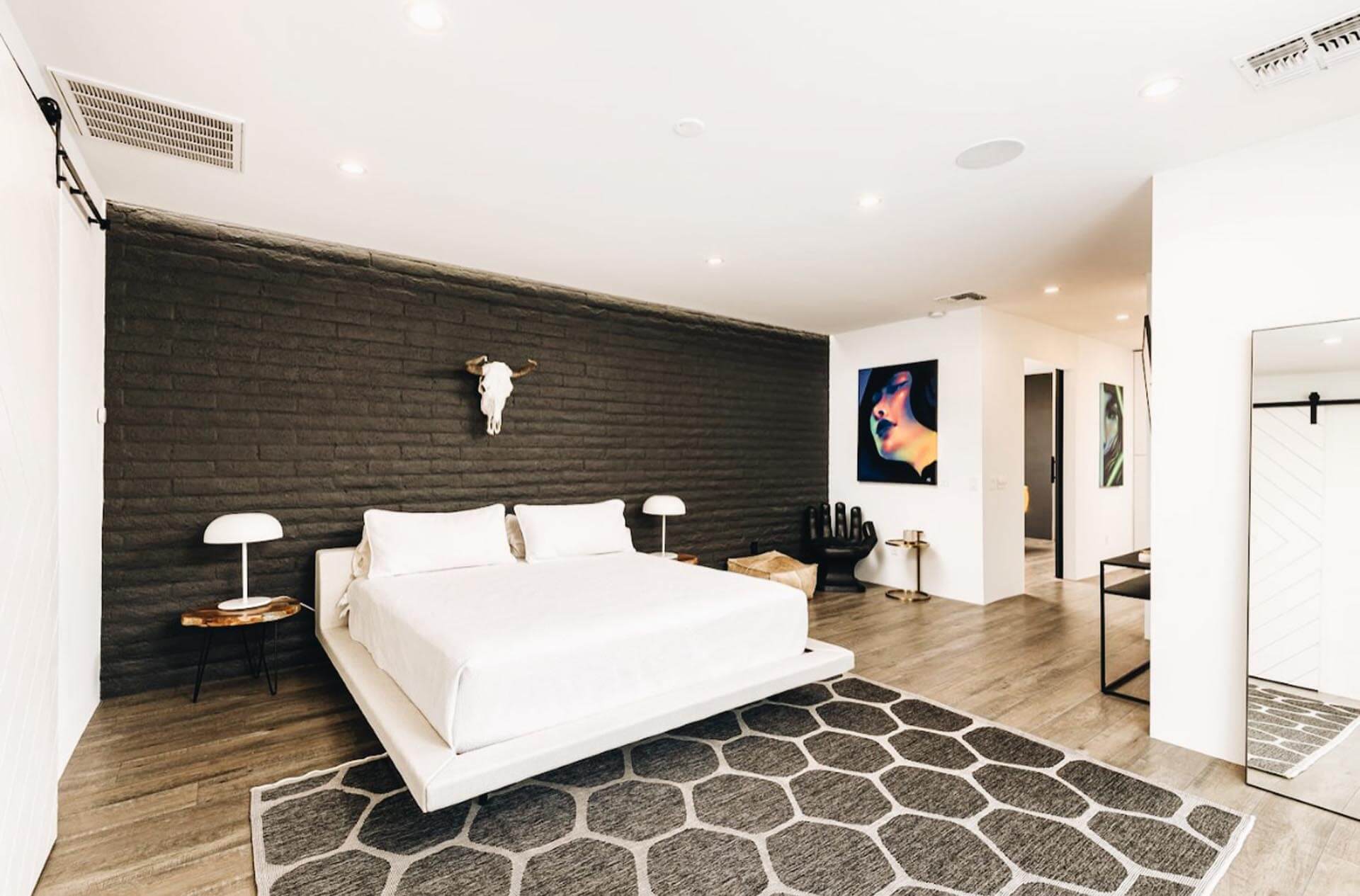 Artfully designed bedroom at the Manor On Camelback, featuring a striking animal skull hanging above and complemented by captivating modern art, offering a unique and stylish ambiance in Phoenix