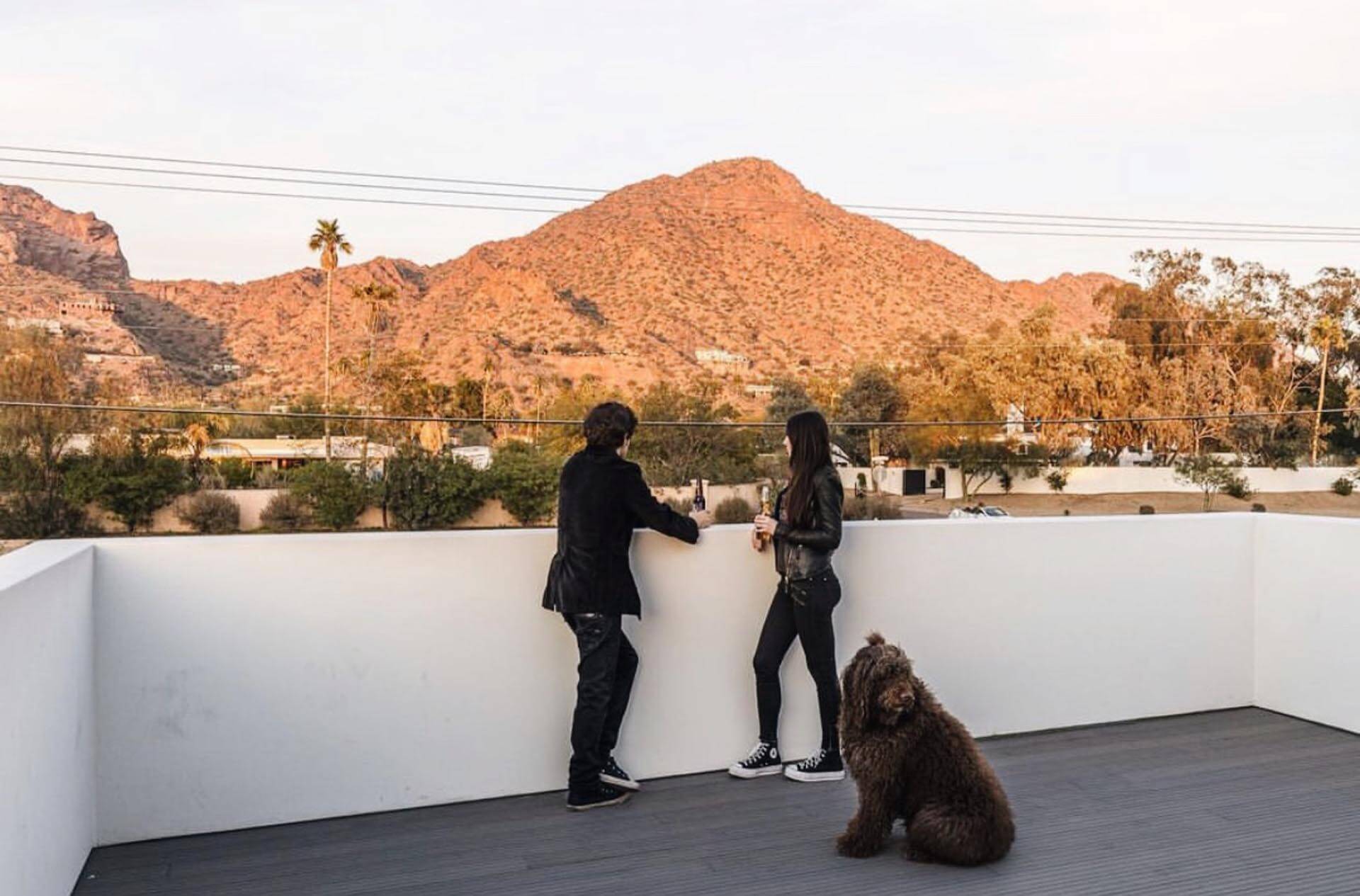 Picturesque outdoor porch at the Manor On Camelback, where a couple enjoys a refreshing beer while admiring the breathtaking view of Camelback Mountain in Phoenix